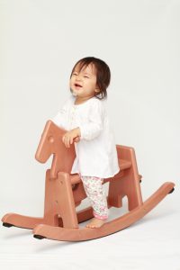Japanese baby girl playing with rocking horse (0 year old)